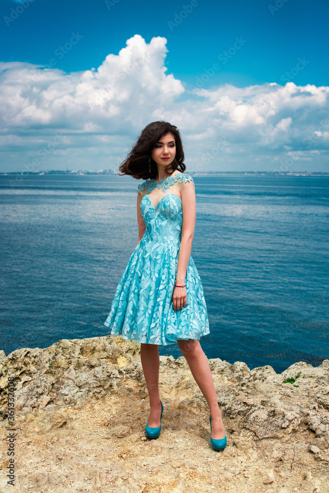 Beautiful young girl in a dress with butterflies on the beach. Portrait ...