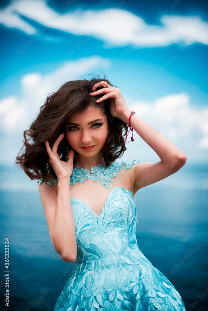 Beautiful young girl in a dress with butterflies on the beach. Portrait ...