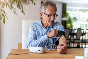 Wall Mural - Senior man using medical device to measure blood pressure
