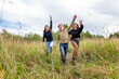 © Юлия Завалишина - Summer holidays vacation happy people concept. Group of three friends boy and two girls running and having fun together outdoors. Picnic with friends on road trip in nature.