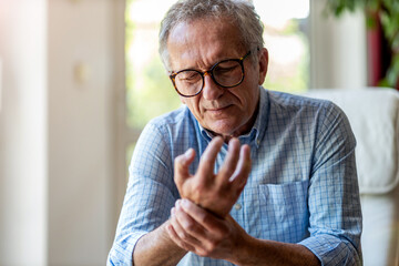 Senior man with arthritis rubbing hands
