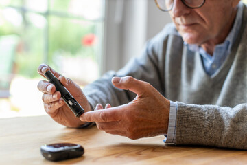 Wall Mural - Mature Man Checking Blood Sugar Level With Glucometer
