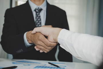 Wall Mural - Partnership. two business man investor handshake deal with partner after finishing up business meeting on desk in meeting room office, financial, teamwork, job interview, contract agreement concept