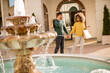 © BGStock72 - Young multiethnic couple walking by the fountain