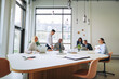 © Flamingo Images - Diverse businesspeople working together around a boardroom table