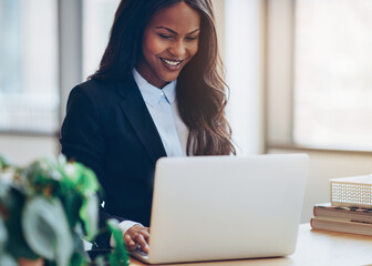 Smiling African American businesswoman using a laptop in her off