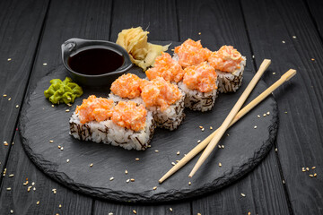 Sushi set nigiri and sushi rolls served on black stone slate