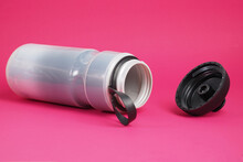 Gray Insulated Plastic Sport Bottle With Open Cap For Cycling On Red Background..
