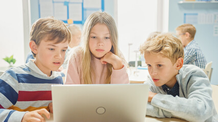 Elementary School Classroom: Diverse Group of Brilliant Children Using Laptop Computer for Software Programming, Talking and Working as a Team. Kids Learning Software Design and Creative Thinking