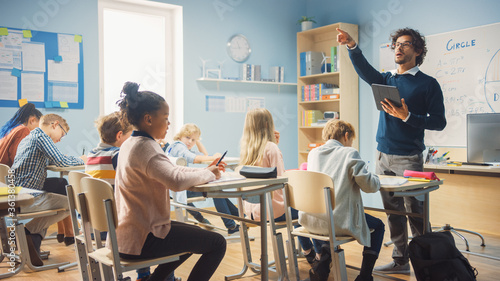 Fotomural Enthusiastic Teacher Giving a Lesson in Elementary School to Class Full of of Diverse Children