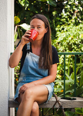 Woman resting on green balcony with many plants