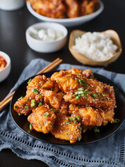 Wall Mural - crispy fried korean chicken wings in galbi sauce with pickled radish, kimchi, and rice side dishes