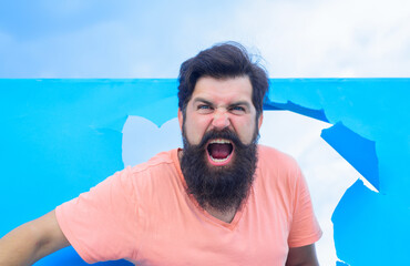 Wall Mural - Advertising. Discount. Sale. Angry man through paper. Copy space for advertising. Excited man looking through hole in paper.