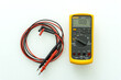 Yellow Digital multimeter with probes for measuring voltage, current, resistance on white background , A multimeter is an electronic measuring instrument.	
