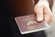 © methaphum - business man hand holding submit offer a passport thailand. asian travel world concept.
