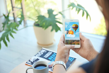 Wall Mural - woman using weather forecast app on smartphone indoors, closeup
