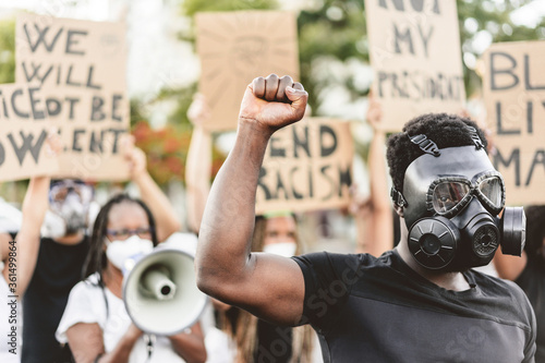 Plakat People from different culture and races protest on the street for equal rights - Demonstrators wearing face and gas masks during black lives matter fight campaign - Focus on black gas mask