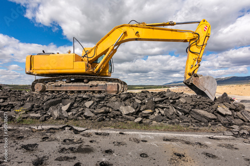 Fotomural Excavator repairing the asphalt of a road