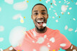 © Carlos David - Portrait of a cheerful black man laughing looking at camera with his arms open and confetti falling around