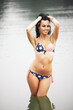 © alipko - Woman on the beach in a swimsuit with an American flag having fun