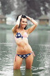 © alipko - Woman on the beach in a swimsuit with an American flag having fun