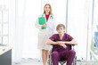 © Masato - Patient in a wheelchair and Female beautiful wearing a doctor uniform standing on the side.