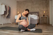 © Impact Photography - Pregnant woman taking a break from workout