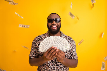 Portrait of his he nice handsome bearded cheerful cheery rich guy holding in hands fan cash currency exchange casino player winner isolated on bright vivid shine vibrant yellow color background