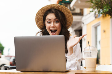 Sticker - Portrait of surprised woman making video call on laptop in cafe