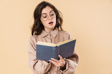 Wall Mural - Image of surprised caucasian woman in eyeglasses reading book