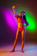 © master1305 - Seductive young girl' portrait isolated on bicolored neon studio background in neon. Fit sportive woman in bodysuit taking selfie. Facial expression, summer, weekend, beauty, resort concept. Vacations