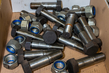 Large bolts and self-locking nuts in a cardboard box for industrial use