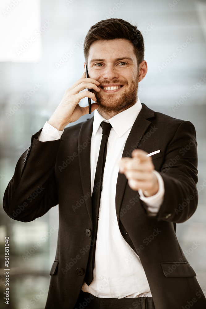 Business concept. Happy smiling young businessman standing in office ...
