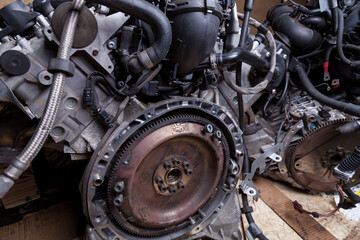 Wall Mural - Closeup of engine with generator and attachments on the background of metal parts in the dark in the maintenance and repair of a car in a car service. Background for a parts store or workshop.