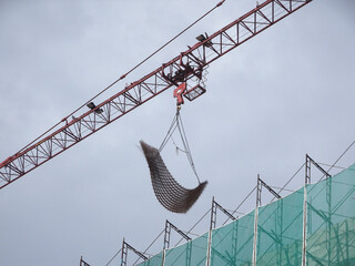 Wall Mural - KUALA LUMPUR, MALAYSIA -MAY 15, 2020: Tower Crane used to lift the heavy load at the construction site. Manually operate by the operator. Normally used at huge scale or high rise building construction