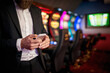 © bugarskipavle3 - Casino manager uses a local cell phone. Close up photo of a young businessman standing in a casino and sends a message.