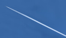 White Trail Of An Airplane On The Blue Sky