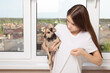 © yta - The problem with dog hair. A young girl at home shows wool on clothes, holds a small pet in her arms