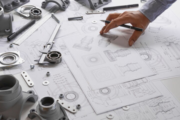 Wall Mural - Engineer technician designing drawings mechanical parts engineering Engine.manufacturing factory Industry Industrial work project blueprints measuring bearings caliper tools