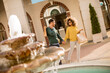 © BGStock72 - Young multiethnic couple walking by the fountain