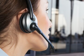 Sticker - A young woman in headphones with a microphone working in a call center