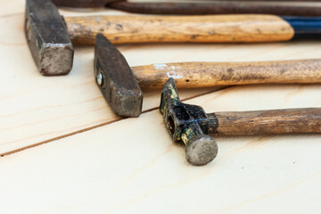 Set of vintage well used hand construction tools for handyman, hammers, on a wooden background .