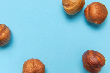 Creative food layout. Hazelnuts on blue background top view copy space. Concept of food, healthy nutrition, nut, healthy fats. Hazelnut Flat lay. Walnut pattern. Organic healthy vegan snack macro shot