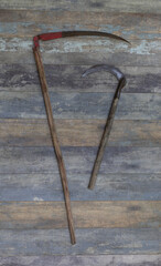 Wall Mural - agricultural scythe on old wooden background