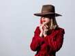 © Masson - Blonde girl in red coat and vintage hat with dial handset