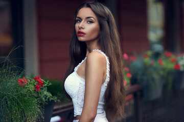 Art fashion vogue style half-length portrait of young beautiful woman with red lips and long hair. Calm stylish girl in white lace top looking at you.