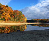 Fototapeta  - Peak Fall foliage around Walden Pond on a crisp Autumn day in Concord Mass