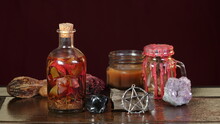 Various Objects Of Wiccan Ritual On A Stone Table - Candles, Crystals, Potion Bottle, Pentagram