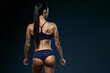 © USM Photography - Healthy fit strong young woman in black sportswear standing with her back looking over her shoulder Copy space Clipping path Rear view Muscular power female back, booty, buttocks