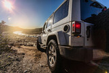 Jeep 4x4 from behind looking toward stream and sun Trabucco Canyon California